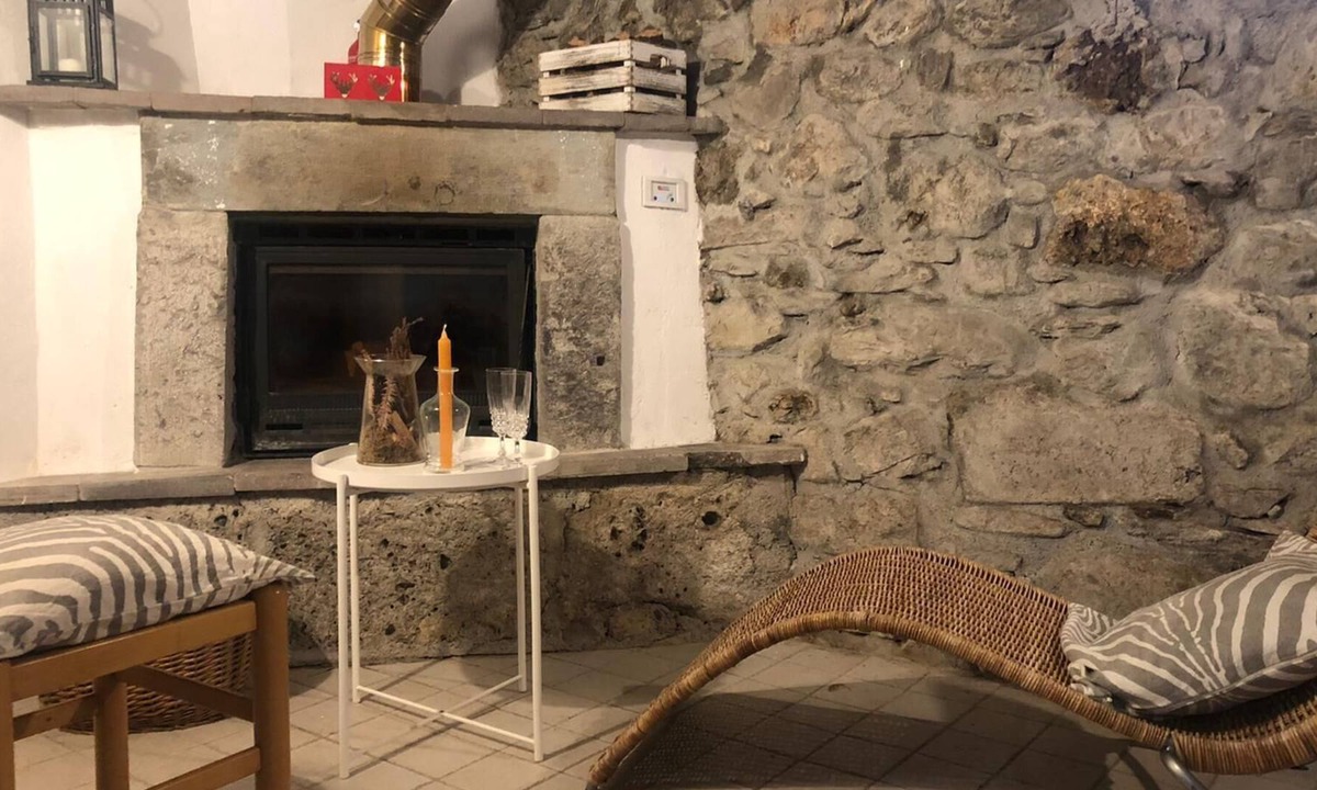 Raveo House | Rustic apartment with beams and stone.